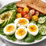 1. A clean, high-resolution image of boiled eggs with vegetables on a healthy breakfast plate